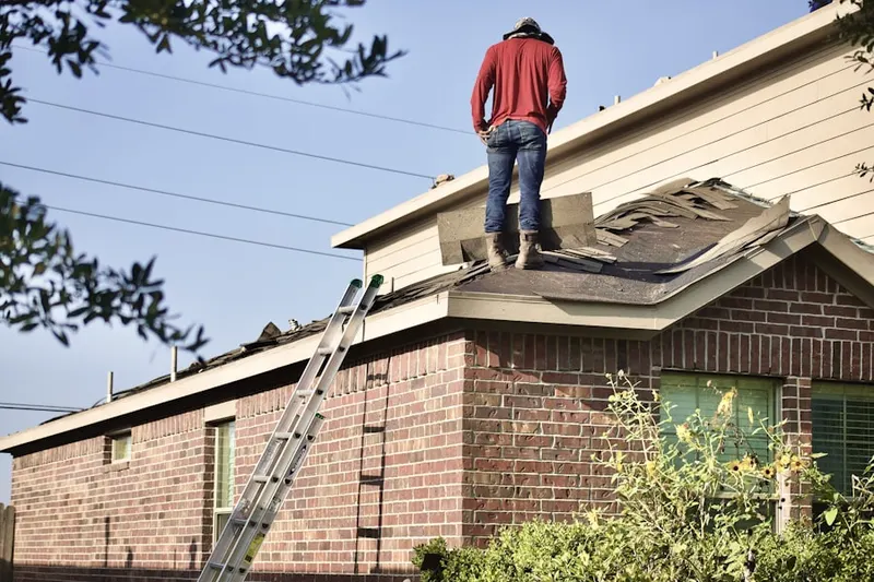 Professional roofer working on a residential roof in Hill Yard